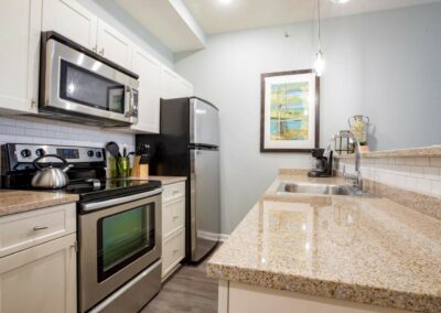 Apartment kitchen with white cabinets and countertops at The Pepper Building